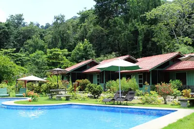 a resort with a pool and chairs and umbrellas at Hacienda Baru in Dominical