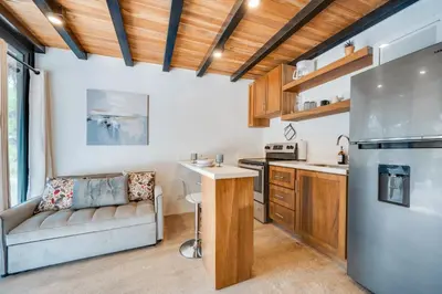 a living room with a couch and a kitchen at 5 Lofts En La Paraiso in Playa Grande