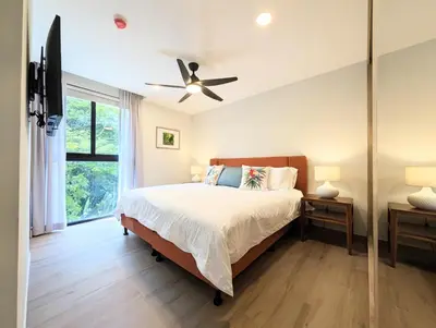 a bedroom with a bed and a ceiling fan at Torres del Mar rainforest-view two-bedroom condo in Jacó