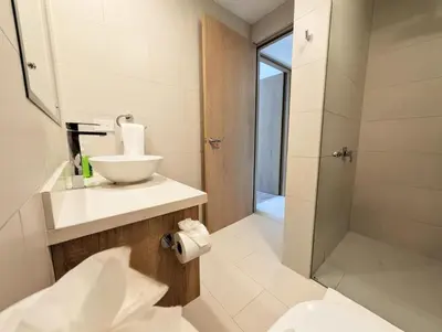 a bathroom with a sink and a shower at Torres del Mar rainforest-view two-bedroom condo in Jacó