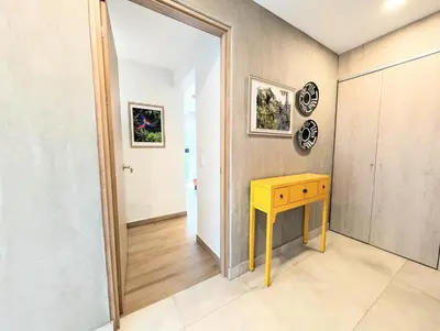 a room with a yellow table and a hallway at Torres del Mar rainforest-view two-bedroom condo in Jacó