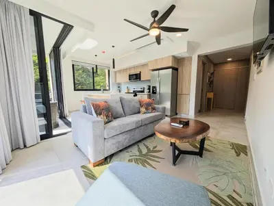 a living room with a couch and a table at Torres del Mar rainforest-view two-bedroom condo in Jacó