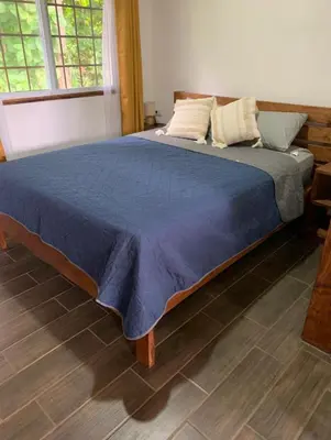 a bedroom with a large bed with a blue comforter at Villas El Silencio - Las Tierras de Leonor in San Juanillo