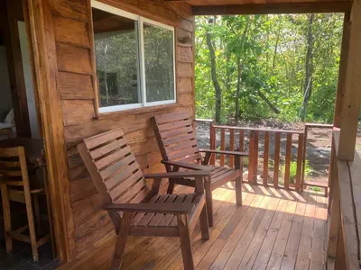 two chairs sitting on a porch of a cabin at Villas El Silencio - Las Tierras de Leonor in San Juanillo