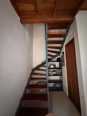 a spiral staircase in a room with a wooden ceiling at Casa Corazón in Cóbano