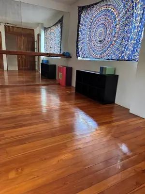a room with a wooden floor and a large tapestry at Casa Corazón in Cóbano