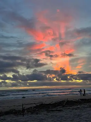 two people walking on the beach at sunset at Casa Corazón in Cóbano
