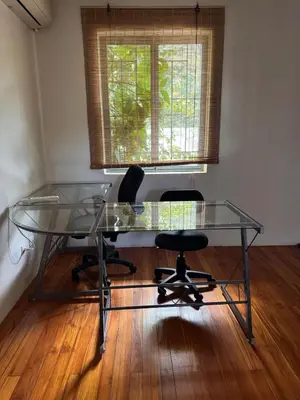 a glass desk with two chairs and a window at Casa Corazón in Cóbano