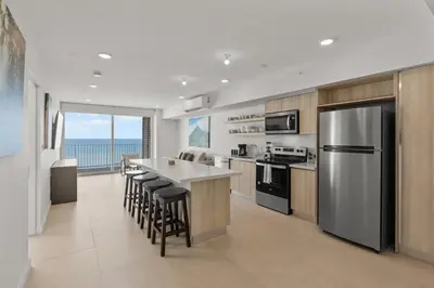 a kitchen with a stainless steel refrigerator and a counter at Oceanfront 3-BR Condo with Stunning Views in Jacó