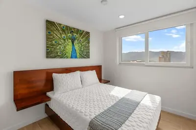 a bedroom with a bed and a painting on the wall at Oceanfront 3-BR Condo with Stunning Views in Jacó