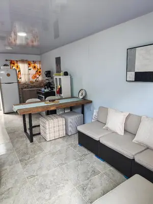 a living room with a couch and a table at Pequeña Casita Karina in Nicoya