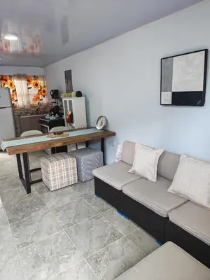 a living room with a couch and a table at Pequeña Casita Karina in Nicoya