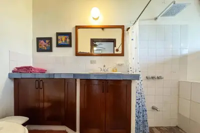 a bathroom with a sink and a mirror at Villas El Parque 18B Central Studio Apartment in Quepos