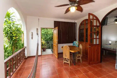 a living room with a ceiling fan and a table at Villas El Parque 18B Central Studio Apartment in Quepos