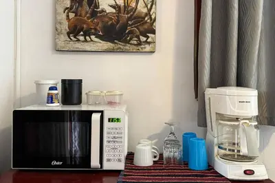 a kitchen counter with a microwave and a coffee maker at Villas El Parque 18B Central Studio Apartment in Quepos