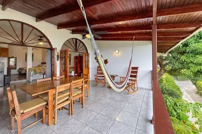 a dining room with a wooden table and a hammock at Villas el Parque 18A 1BR Central Apartment w Huge Patio in Quepos