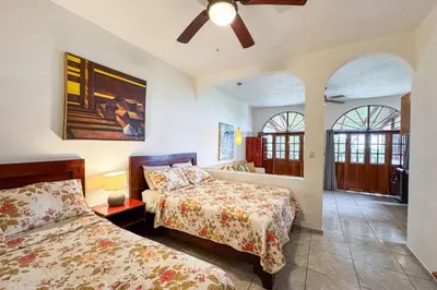 a bedroom with two beds and a ceiling fan at Villas el Parque 18A 1BR Central Apartment w Huge Patio in Quepos