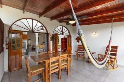 a room with a wooden table and a hammock at Villas el Parque 18A 1BR Central Apartment w Huge Patio in Quepos