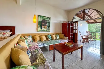 a living room with a couch and a table at Villas el Parque 18A 1BR Central Apartment w Huge Patio in Quepos