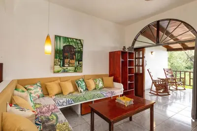 a living room with a couch and a table at Villas el Parque 18A 1BR Central Apartment w Huge Patio in Quepos