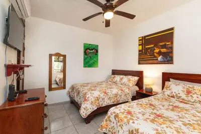 a bedroom with two beds and a ceiling fan at Villas el Parque 18A 1BR Central Apartment w Huge Patio in Quepos