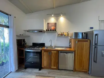 a kitchen with a stove and a refrigerator at Palco Pacífico Villa with Private Rooftop Pool in Alto del Monte