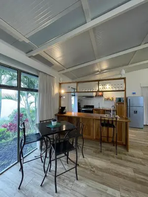 a living room with a table and a kitchen at Palco Pacífico Villa with Private Rooftop Pool in Alto del Monte