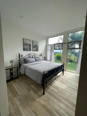 a bedroom with a large bed and a large window at Palco Pacífico Villa with Private Rooftop Pool in Alto del Monte
