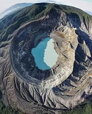 an aerial view of a mountain with a blue lake at Lagunillas Del Poas in Poasito