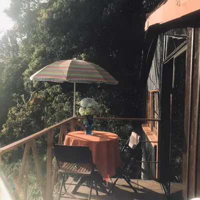 a table with a vase of flowers and an umbrella at Lagunillas Del Poas in Poasito
