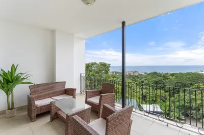 a balcony with chairs and a table and a view of the ocean at Mir3 Tamarindo 2BR Ocean View Retreat in Tamarindo