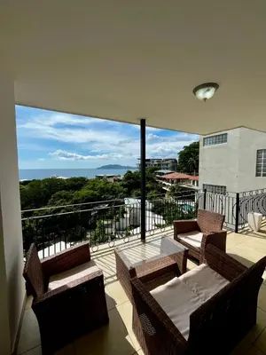 a balcony with couches and chairs on a balcony at Mir3 Tamarindo 2BR Ocean View Retreat in Tamarindo