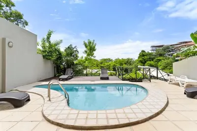 a swimming pool on a patio with chairs around it at Mir3 Tamarindo 2BR Ocean View Retreat in Tamarindo