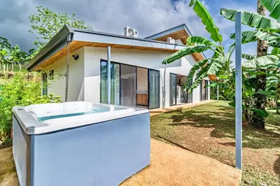 a bath tub in front of a house at Private rainforest villa up to 8 guests w jacuzzi near Rio Celeste in Upala
