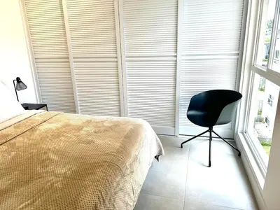 a bedroom with a bed and a chair next to a window at Charming Apartment in Curridabat in Granadilla