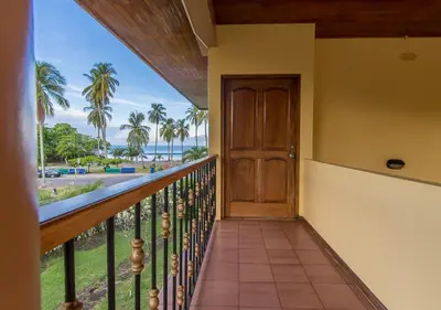 a balcony with a door and a view of the beach at Hotel Manuel Antonio in Manuel Antonio