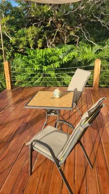a table and a chair on a wooden deck at Casa Boa Casita Tambor in La Abuela