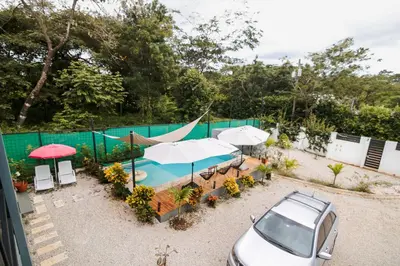 a car parked next to a swimming pool with umbrellas at Casa Ola Ini Studio Playa Grande in Playa Grande