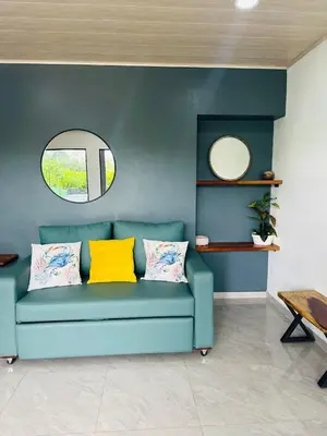 a blue couch in a living room with a mirror at Casa Ola Ini Studio Playa Grande in Playa Grande