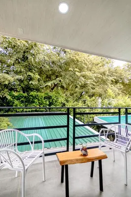a balcony with two chairs and a wooden table at Casa Ola Ini Studio Playa Grande in Playa Grande
