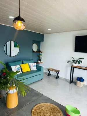 a living room with a blue couch and a tv at Casa Ola Ini Studio Playa Grande in Playa Grande