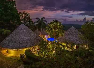 an aerial view of a resort withiki huts at night at TikiVibez in Coronado