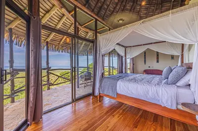 a bedroom with a canopy bed with a view of the ocean at TikiVibez in Coronado