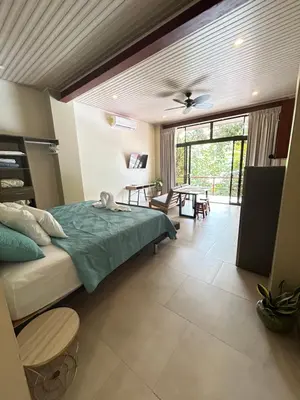 a bedroom with a bed and a table with chairs at Apartamentos Margarita in Quepos