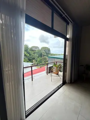 a view of a balcony from a room with a sliding glass door at Apartamentos Margarita in Quepos