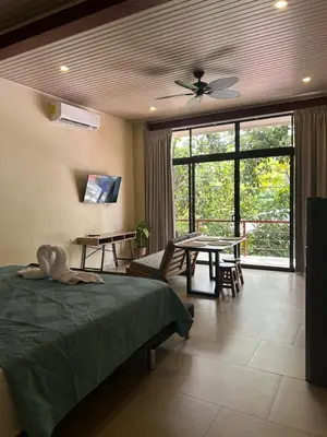 a bedroom with a bed and a dining room with a table at Apartamentos Margarita in Quepos