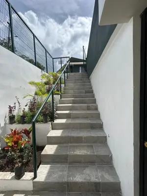 a stairway leading up to a building with potted plants at Apartamentos Margarita in Quepos