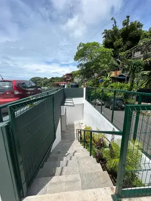 a stairway with a green gate and a car at Apartamentos Margarita in Quepos