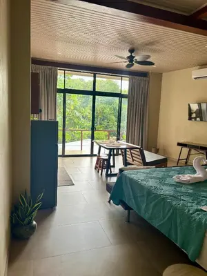 a bedroom with a bed and a table with a table at Apartamentos Margarita in Quepos