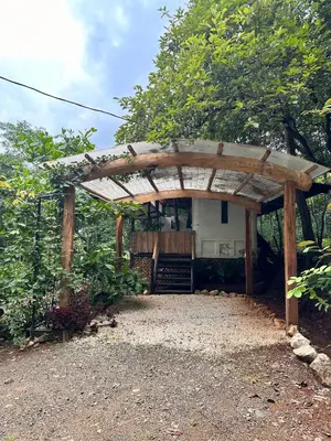 a wooden pergola with a house in the background at Casa Laurel in Santa Cruz